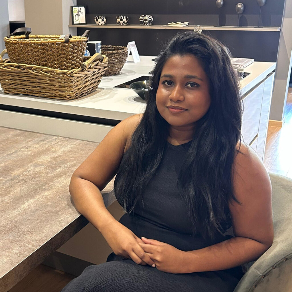 A professional team member from Häcker Sri Lanka sitting at a modern showroom table.